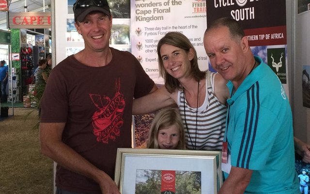 From the left: Sean and Michelle Privett, with their daughter, Emma, between them, receiving the award from the Getaway Show organiser